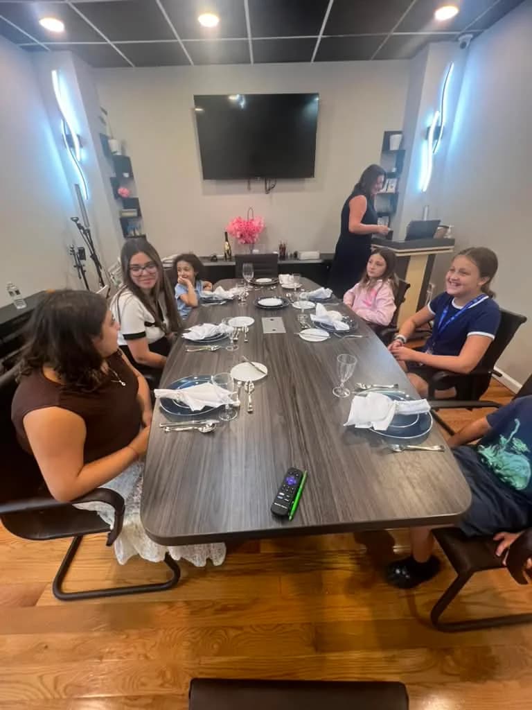 Students practicing table manners together during an Exceed etiquette class